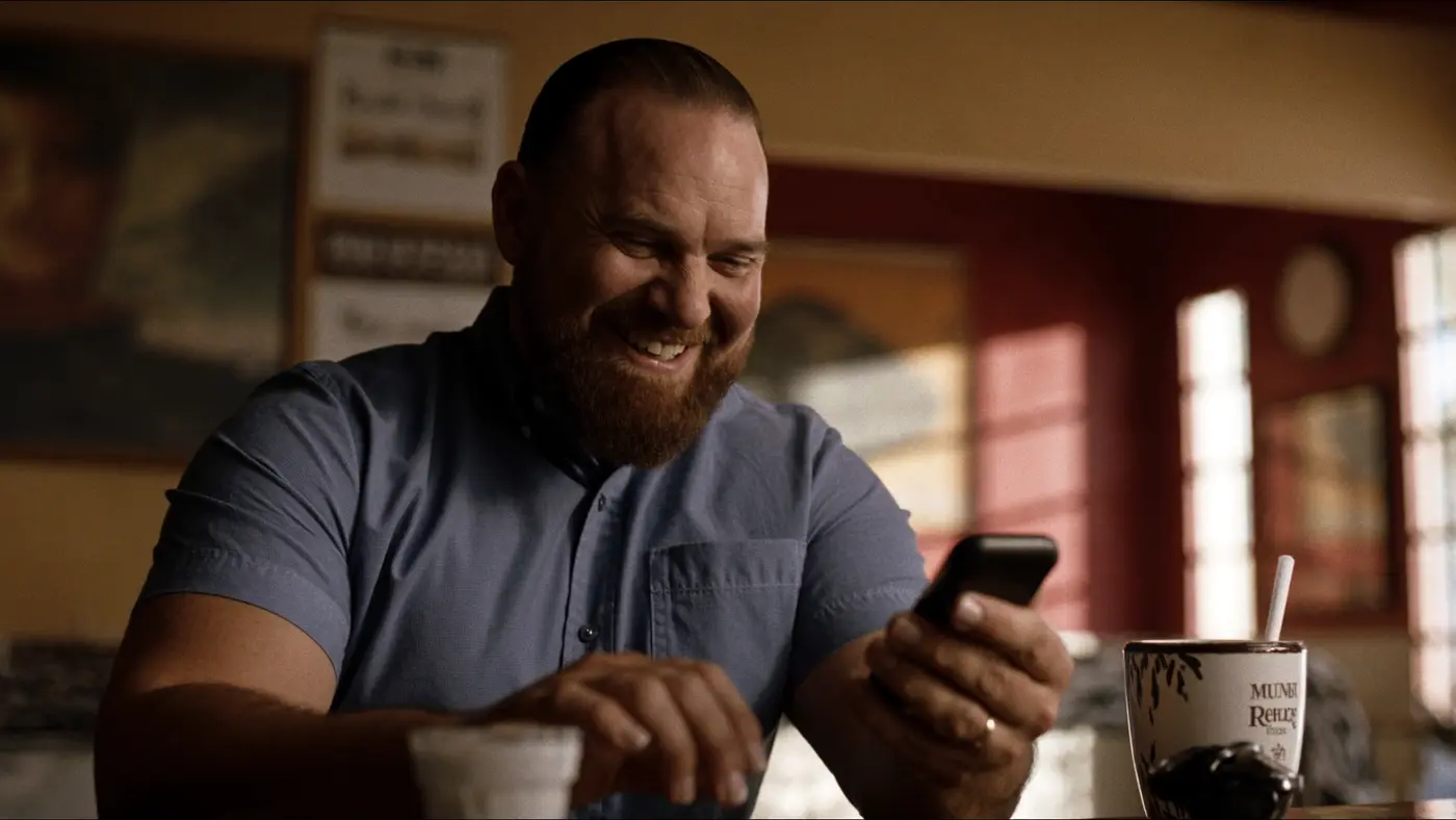 El dueño sonríe al ver su celular por la mañana